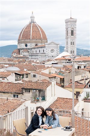 Lesbian couple sitting at table on roof terrace in front of Giotto's Campanile and Florence Cathedral, Tuscany, Italy Stock Photo - Premium Royalty-Free, Code: 649-08306705