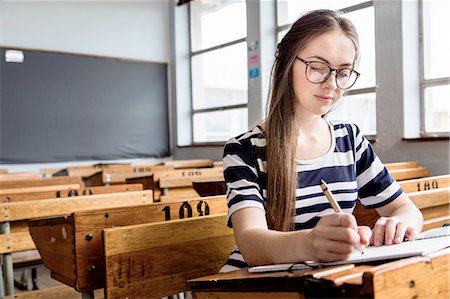 pupil in a empty classroom - Female student working in empty classroom Stock Photo - Premium Royalty-Free, Code: 649-08306859