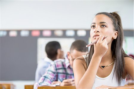 Female student, sitting at desk in classroom, thinking Stock Photo - Premium Royalty-Free, Code: 649-08306919