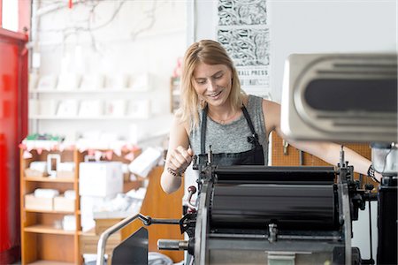 Young woman working on traditional letterpress print machine in workshop Stock Photo - Premium Royalty-Free, Code: 649-08307050