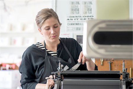 Female letterpress printer inking machine in workshop Stock Photo - Premium Royalty-Free, Code: 649-08307053