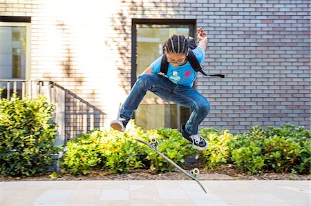 simsearch:649-07710443,k - Boy doing skateboarding trick jump on urban sidewalk Stock Photo - Premium Royalty-Free, Code: 649-08307190