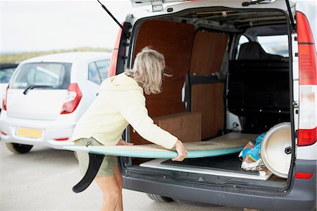 Senior woman putting surfboard in open van Stock Photo - Premium Royalty-Free, Code: 649-08307226