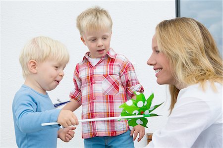 simsearch:614-07806393,k - Mother and two young sons playing with pinwheel on patio Stock Photo - Premium Royalty-Free, Code: 649-08307419