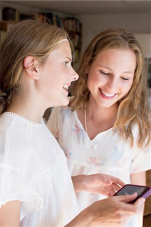 simsearch:649-07804673,k - Two teenage girls reading smartphone texts Photographie de stock - Premium Libres de Droits, Code: 649-08307508