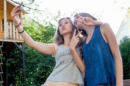 simsearch:649-07804673,k - Two teenage girls posing for smartphone selfie in garden Photographie de stock - Premium Libres de Droits, Code: 649-08307518