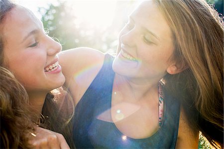 friends laughing - Close up of two teenage girls in sunlit park Stock Photo - Premium Royalty-Free, Code: 649-08307520