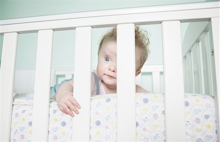 Portrait of baby girl looking through bars on cot Stock Photo - Premium Royalty-Free, Code: 649-08327690