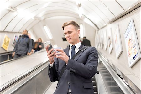 stood up - Businessman texting on escalator, London Underground, UK Stock Photo - Premium Royalty-Free, Code: 649-08327786