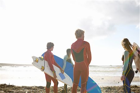 Group of surfers standing on beach, holding surfboards, rear view Foto de stock - Sin royalties Premium, Código: 649-08327909