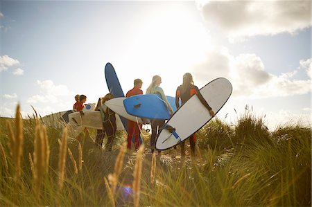 Group of surfers standing on beach, holding surfboards, rear view Foto de stock - Sin royalties Premium, Código: 649-08327913