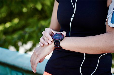 sport or fitness (activity) - Cropped shot of young female runner setting smartwatch Stock Photo - Premium Royalty-Free, Code: 649-08328378