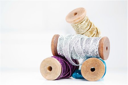 ribbon (material) - Stack of wooden reel with sparkly silver, gold, blue and purple ribbons Stock Photo - Premium Royalty-Free, Code: 649-08329076