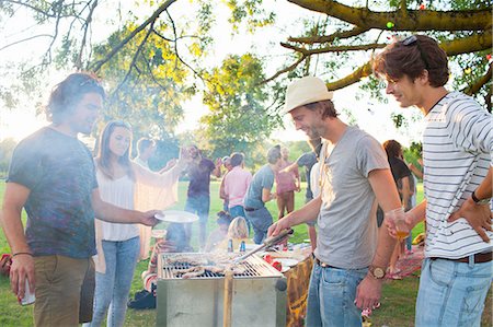 Happy adult friends barbecuing at sunset party in park Foto de stock - Sin royalties Premium, Código: 649-08381087