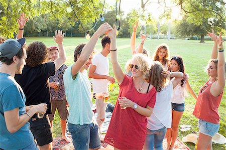 simsearch:649-08381087,k - Crowd of adult friends dancing at party in park at sunset Foto de stock - Sin royalties Premium, Código: 649-08381081