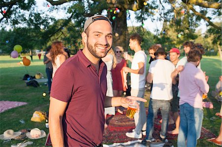 simsearch:649-08381087,k - Portrait of young man at crowded party in park at sunset Foto de stock - Sin royalties Premium, Código: 649-08381082