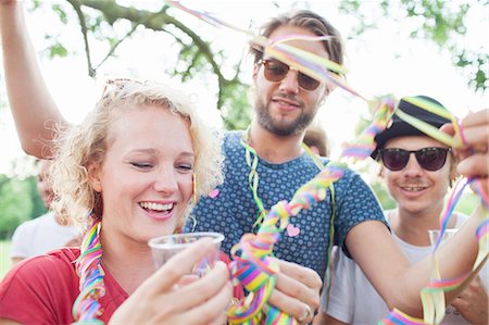 simsearch:649-08381087,k - Adult friends wrapping each other in streamers at sunset party in park Foto de stock - Sin royalties Premium, Código: 649-08381091