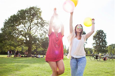 simsearch:649-08381087,k - Two young women dancing with balloons at park party Foto de stock - Sin royalties Premium, Código: 649-08381134