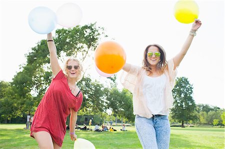 simsearch:649-08381087,k - Portrait of two young women dancing with balloons at park party Foto de stock - Sin royalties Premium, Código: 649-08381135
