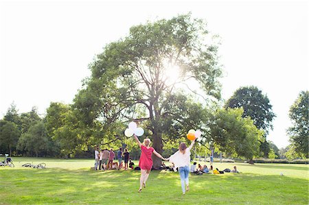 simsearch:649-08381087,k - Rear view of two young women dancing with balloons at park party Foto de stock - Sin royalties Premium, Código: 649-08381136