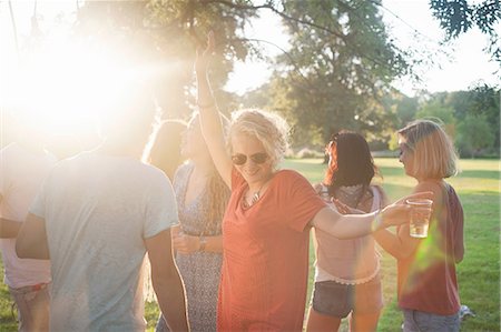 simsearch:649-08381087,k - Adult friends dancing and drinking in park at sunset Foto de stock - Sin royalties Premium, Código: 649-08381179