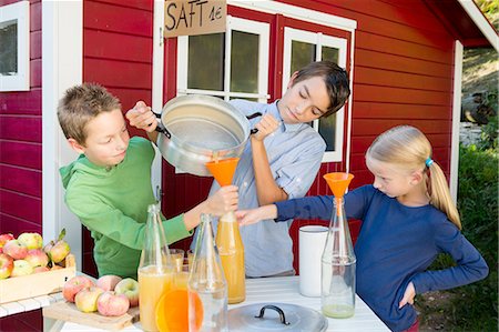 simsearch:649-08180244,k - Teenage boy and siblings pouring fresh orange juice to sell at roadside Stock Photo - Premium Royalty-Free, Code: 649-08381221
