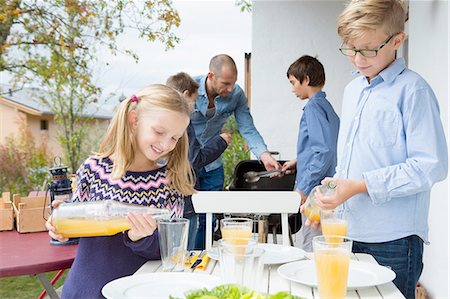 simsearch:649-07648247,k - Girl and brother pouring juice at garden barbecue table Stock Photo - Premium Royalty-Free, Code: 649-08381266