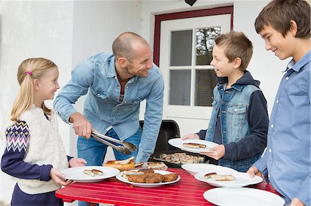 simsearch:649-07648247,k - Father serving food to children at garden barbecue table Stock Photo - Premium Royalty-Free, Code: 649-08381267