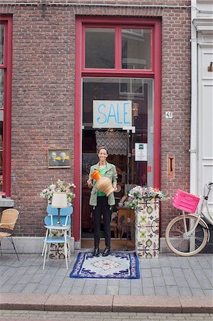 small business portrait full body - Portrait of young female customer holding jug outside vintage shop Stock Photo - Premium Royalty-Free, Code: 649-08381289