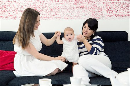 Mature woman and daughter playing with baby girl on sofa Stock Photo - Premium Royalty-Free, Code: 649-08381714