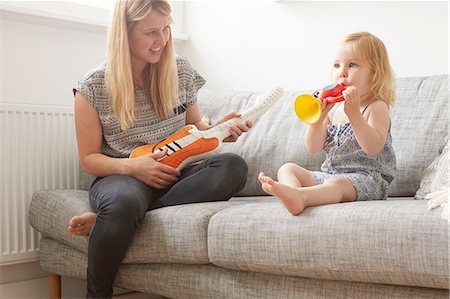simsearch:649-08422552,k - Female toddler and mother playing with toy trumpet and guitar on sofa Foto de stock - Sin royalties Premium, Código: 649-08422597