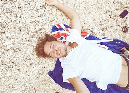 simsearch:649-07280729,k - Overhead view of young man lying on back on beach on beach towel, looking away smiling, Costa Smeralda, Sardinia, Italy Stock Photo - Premium Royalty-Free, Code: 649-08422664