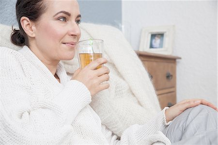 Woman relaxing at home, having a drink Stock Photo - Premium Royalty-Free, Code: 649-08422836
