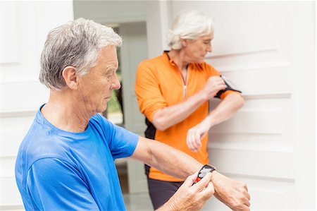 Two senior male runners at front door synchronising smartwatch and smartphone Stock Photo - Premium Royalty-Free, Code: 649-08423213