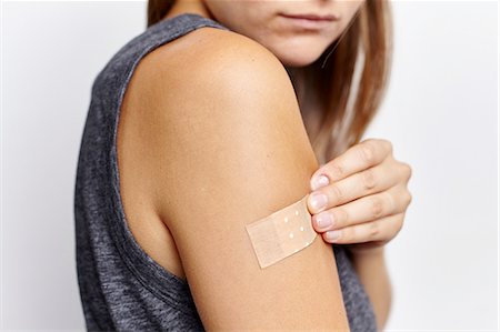 plasters - Woman applying plaster on right arm Stock Photo - Premium Royalty-Free, Code: 649-08479311