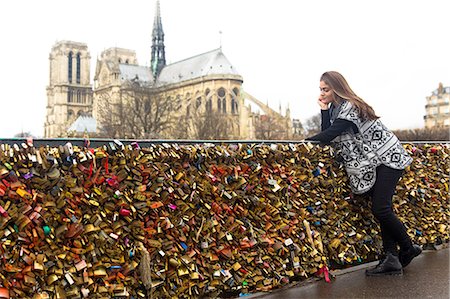 simsearch:841-07083487,k - Young woman leaning against love locks, Pont de l'archeveche, Notre Dame Cathedral in background, Paris, France Stock Photo - Premium Royalty-Free, Code: 649-08479326