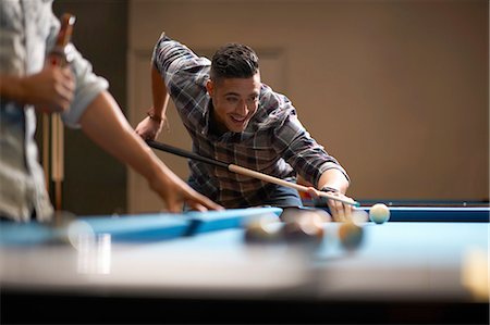 Man playing pool, friend with beer in foreground Stock Photo - Premium Royalty-Free, Code: 649-08480201
