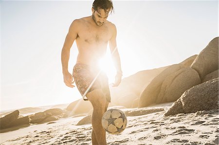 simsearch:649-07585546,k - Mid adult man wearing swimming shorts playing soccer keepy uppy on beach, Cape Town, South Africa Stock Photo - Premium Royalty-Free, Code: 649-08544027