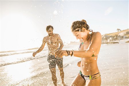 simsearch:649-07585546,k - Mid adult couple wearing bikini and shorts splashing on beach, Cape Town, South Africa Stock Photo - Premium Royalty-Free, Code: 649-08544020