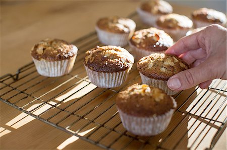 Hand picking up gluten free muffins from cooling tray Stock Photo - Premium Royalty-Free, Code: 649-08548303