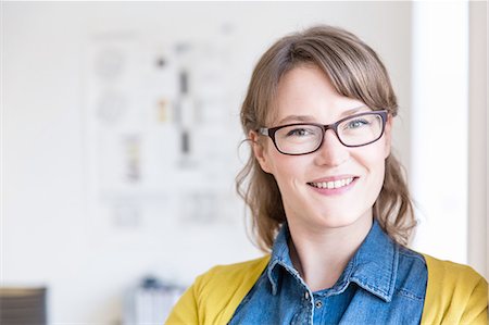 denim shirt - Portrait of young woman wearing eye glasses looking at camera smiling Stock Photo - Premium Royalty-Free, Code: 649-08548455