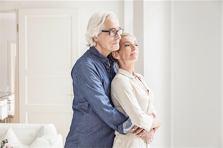 Couple hugging, looking out of window Stock Photo - Premium Royalty-Free, Code: 649-08548671