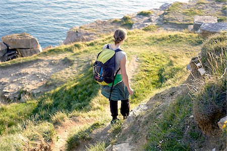 simsearch:649-08086253,k - High angle rear view of hiker with backpack hiking down cliff side, Portland, UK Stock Photo - Premium Royalty-Free, Code: 649-08548851