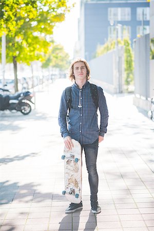 simsearch:649-07710443,k - Portrait of confident young male urban skateboarder standing on sidewalk Stock Photo - Premium Royalty-Free, Code: 649-08548889