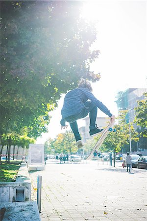 simsearch:649-07710443,k - Young male skateboarder doing skateboarding jump on sidewalk Stock Photo - Premium Royalty-Free, Code: 649-08548897