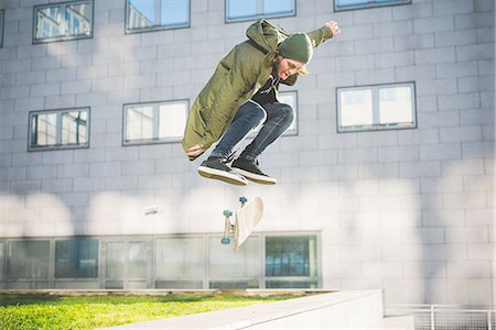 simsearch:649-07710443,k - Young male urban skate boarder skateboarding mid air over wall Stock Photo - Premium Royalty-Free, Code: 649-08548916