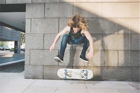 simsearch:649-07710443,k - Young male urban skateboarder doing skateboarding jump trick above skateboard Stock Photo - Premium Royalty-Free, Code: 649-08548922