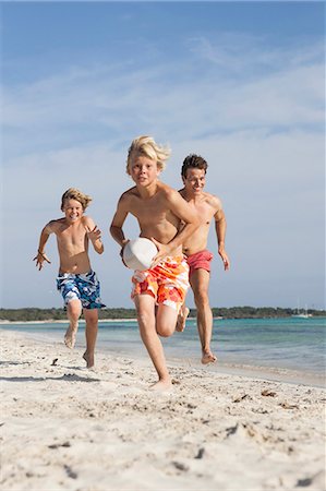 simsearch:649-07648247,k - Boy running with rugby ball chased by brother and father on beach, Majorca, Spain Stock Photo - Premium Royalty-Free, Code: 649-08543613