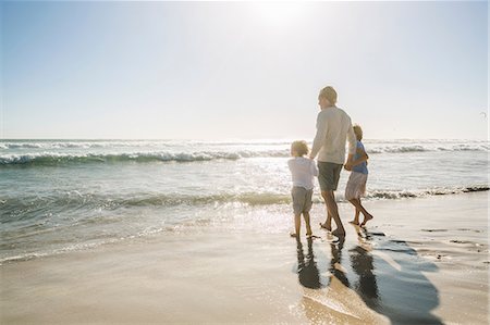 father son shore - Rear view of father and sons on beach looking away at view Stock Photo - Premium Royalty-Free, Code: 649-08543804