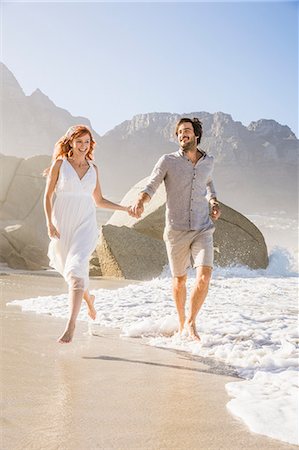 dressing - Full length front view of couple running on beach holding hands Stock Photo - Premium Royalty-Free, Code: 649-08543872